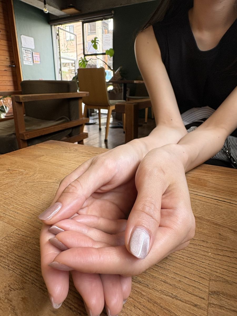 カフェのテーブルで両手を重ねている様子